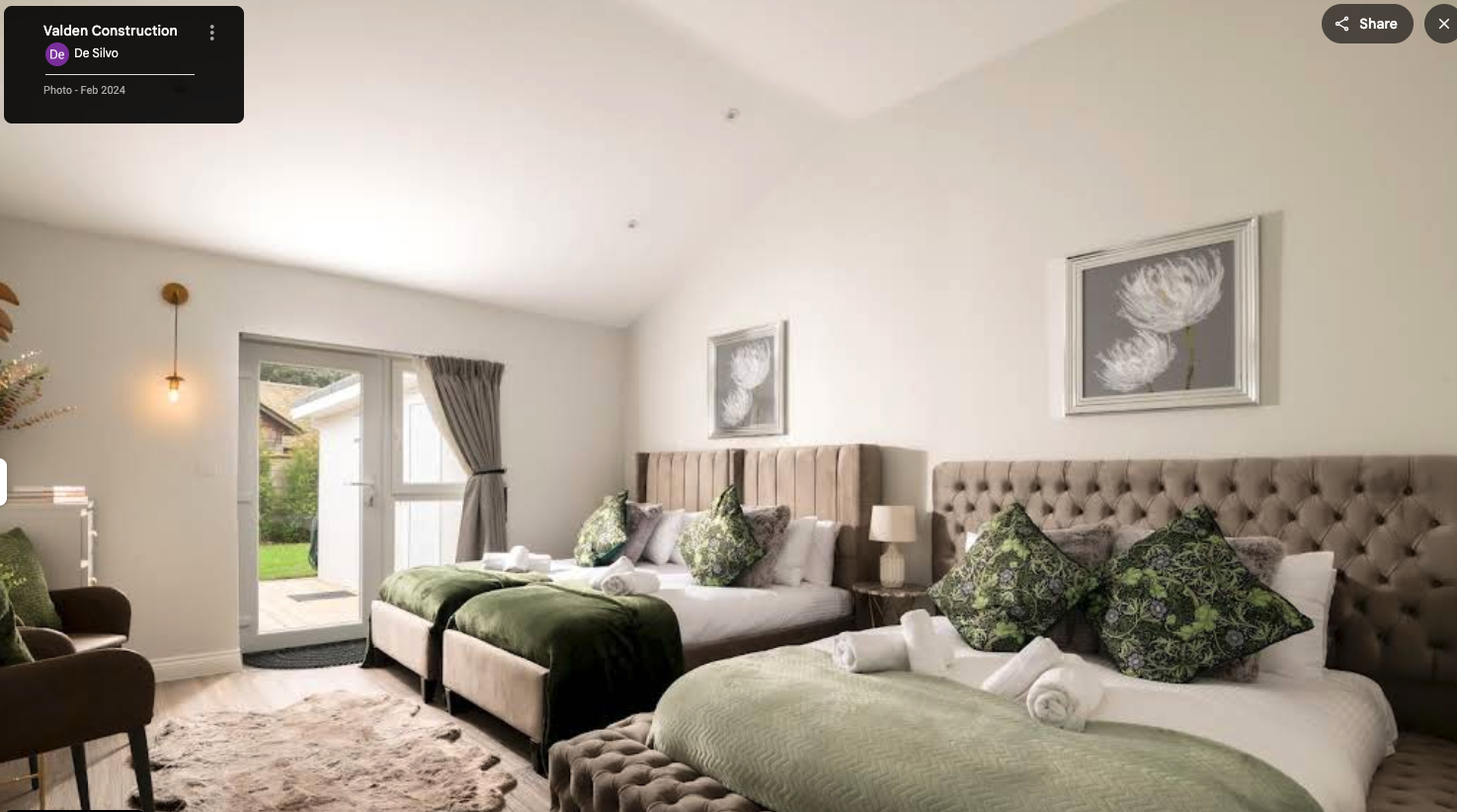 Luxury bedroom interior with twin beds, vaulted ceiling and garden access